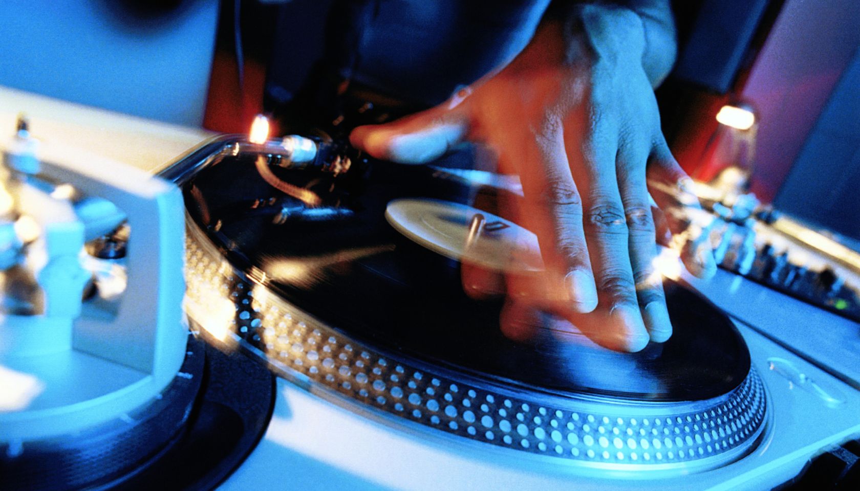 DISC JOCKEY, HAND ON TURNTABLE, CLOSE-UP (LONG EXPOSURE)