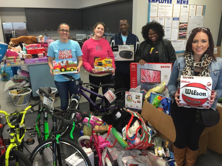 Mir.I.am with Salvation Army staff, as they pose with all donations