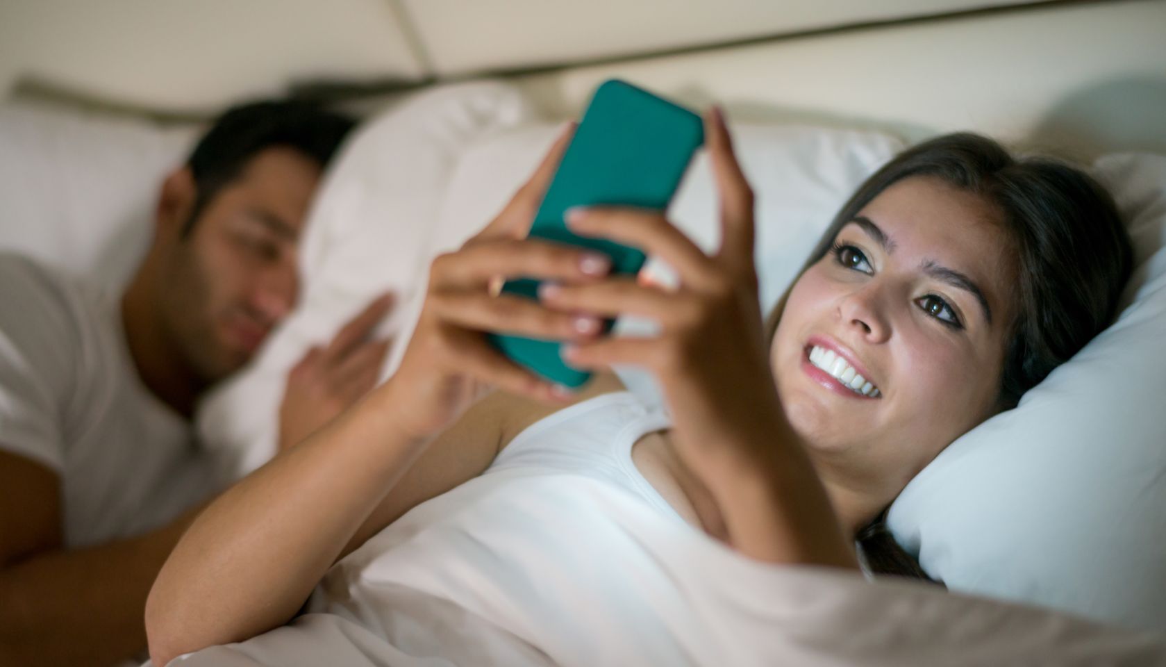 Woman social networking in bed on her phone