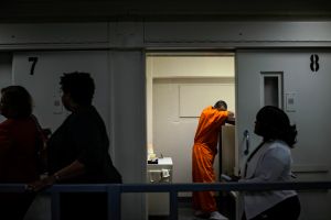 Members of DC Mayor Muriel Bowser's entourage walk past an inmate's cell as she tours DC Central Jail after announcing policy changes to support employment for inmates during and after incarceration in Washington...