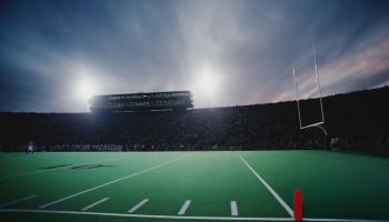 Football stadium filled with spectators during game, twilight