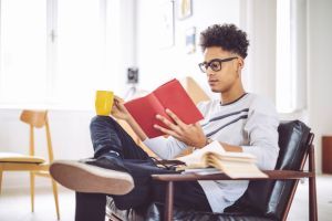 Young man reading a book at home