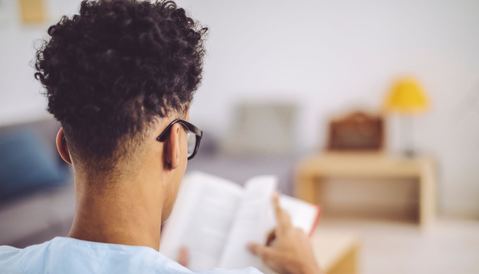 Young man reading a book at home