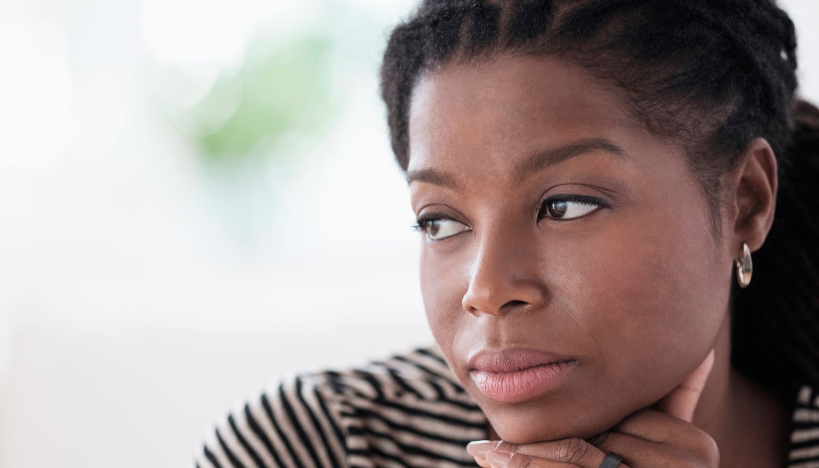 Black woman resting chin in hand