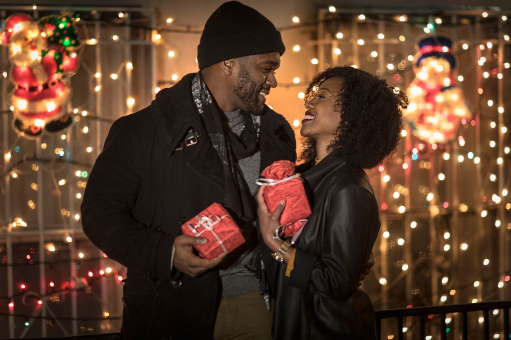 Romantic couple exchanging christmas gifts at night, New York, USA