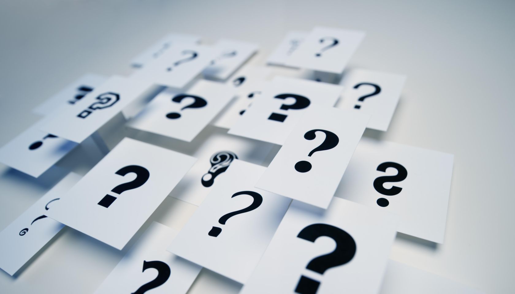 Multiple question marks on paper
