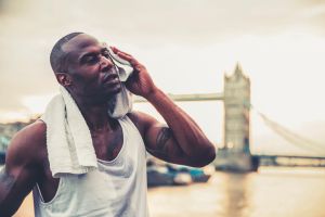 Drying the sweat with a towel post workout near Tower Bridge, London