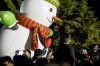 People enjoy as a snowman float passes by during a Christmas...