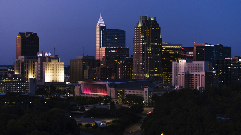 Illuminated office buildings rise in night Downtown Raleigh in North Carolina